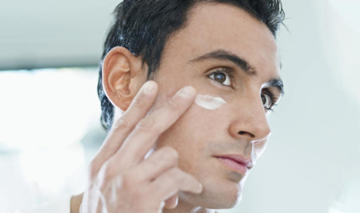 homme appliquant de la crème anti-rides