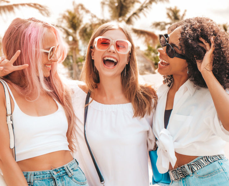 3 femmes avec coiffure d'été devant la plage avec un grand sourire