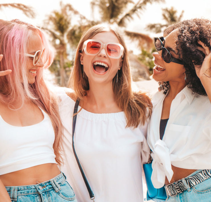 3 femmes avec coiffure d'été devant la plage avec un grand sourire